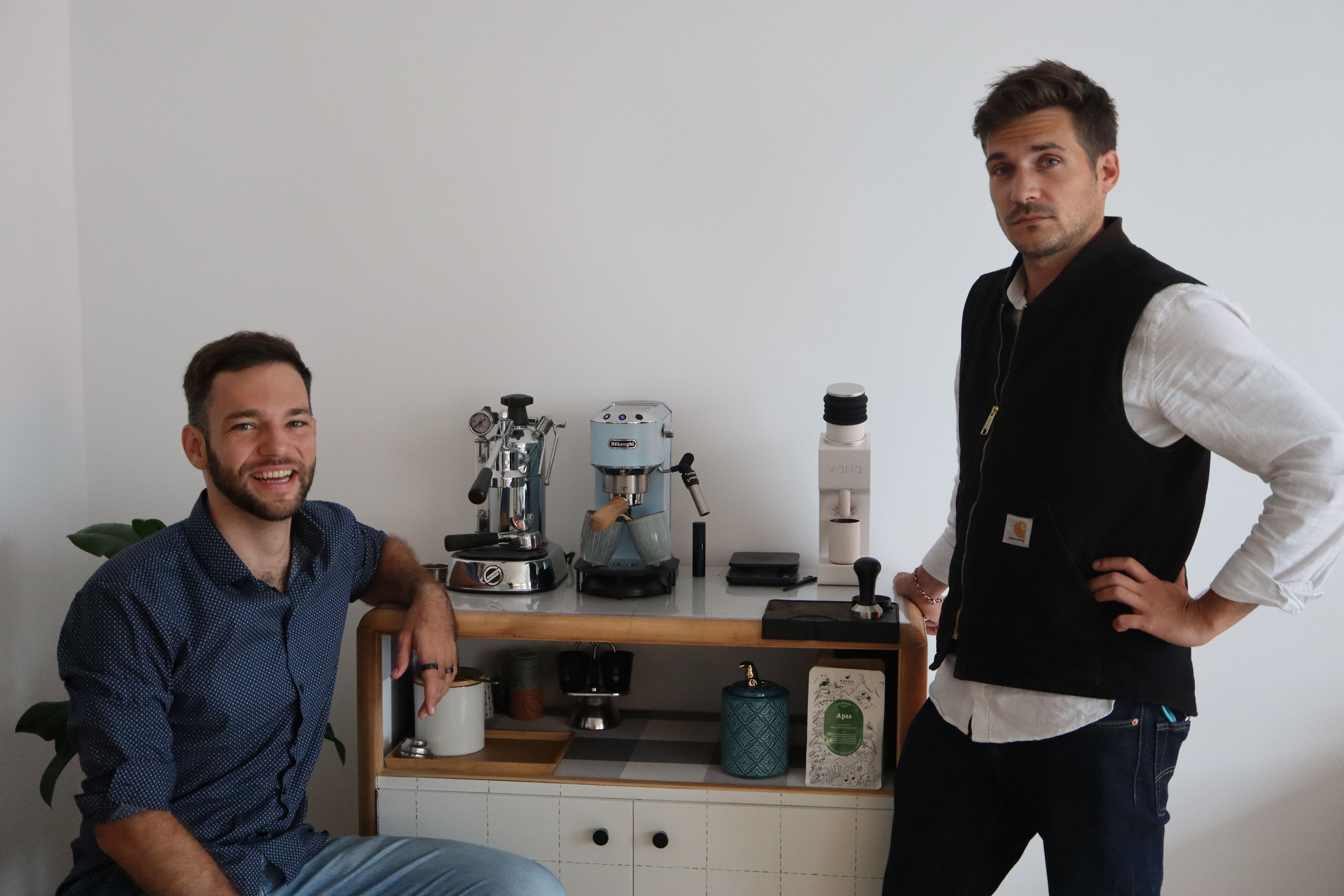 Raphael and Clemens sitting in front of a coffee machine